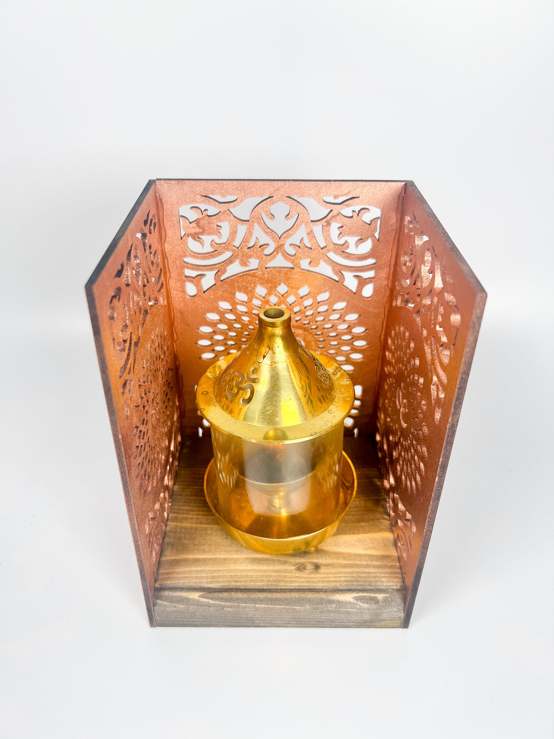 Decorative lantern with intricate cut-out design and a gold candle holder on a white background